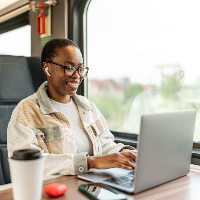 Woman working on laptop on train