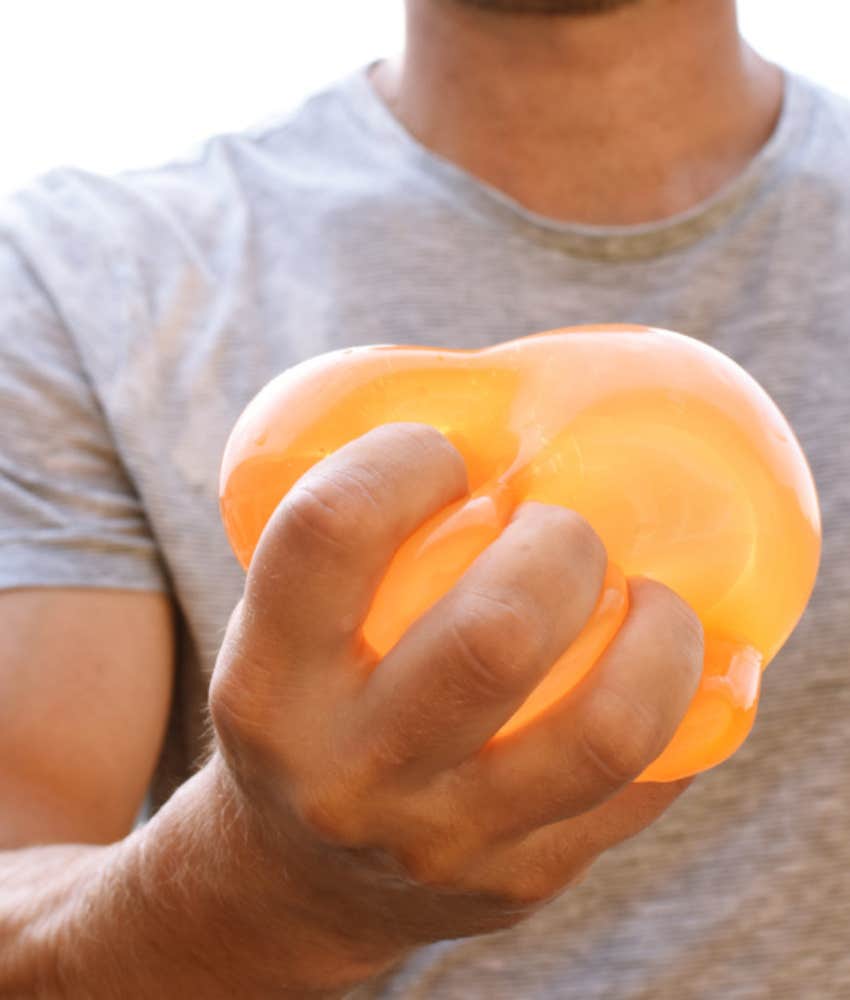 man holding orange water balloon