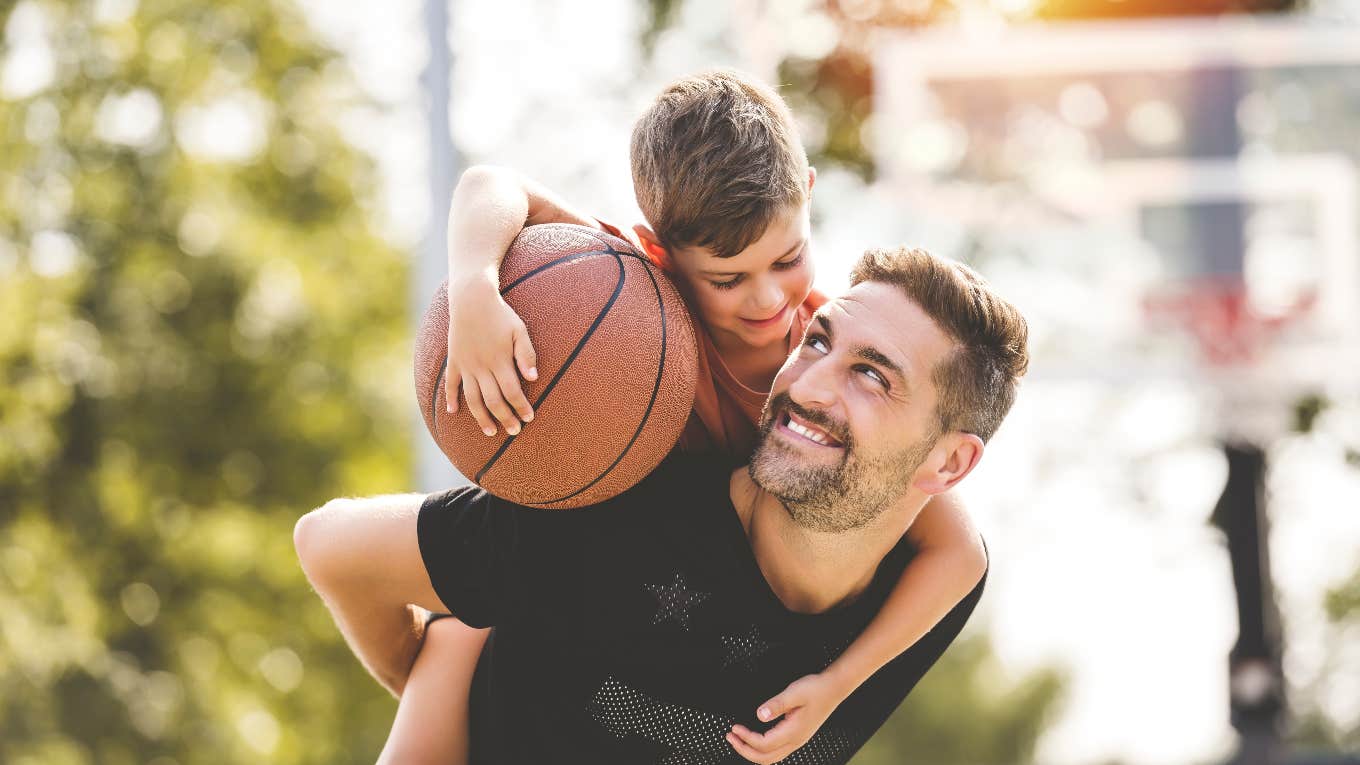 Dad holding son with basketball