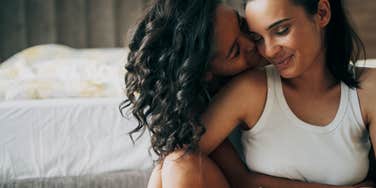 two women embrace each other in hotel room