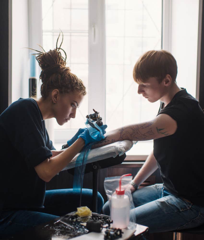 woman tattooing customer