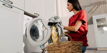 woman loading laundry into washing machine