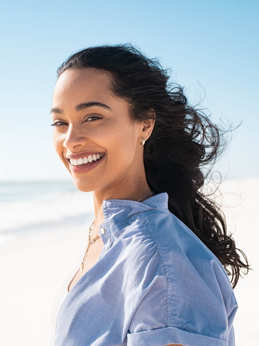 Smiling woman on the beach has learned to be happy