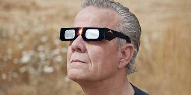 man wearing eclipse glasses 