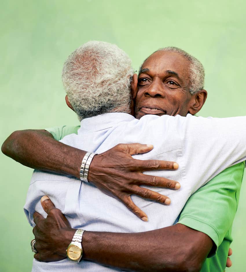 two elderly men hug