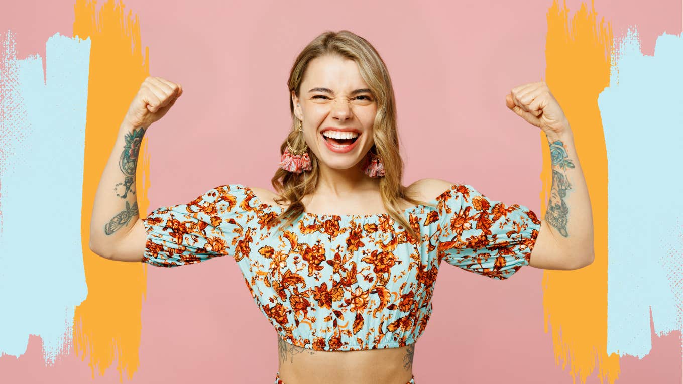 Strong woman smiling, flexing in a flowery top, in front of pink background