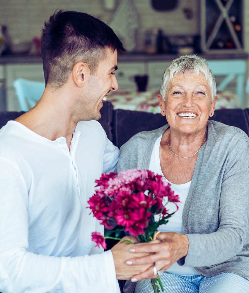 adult son giving mom pink flowers