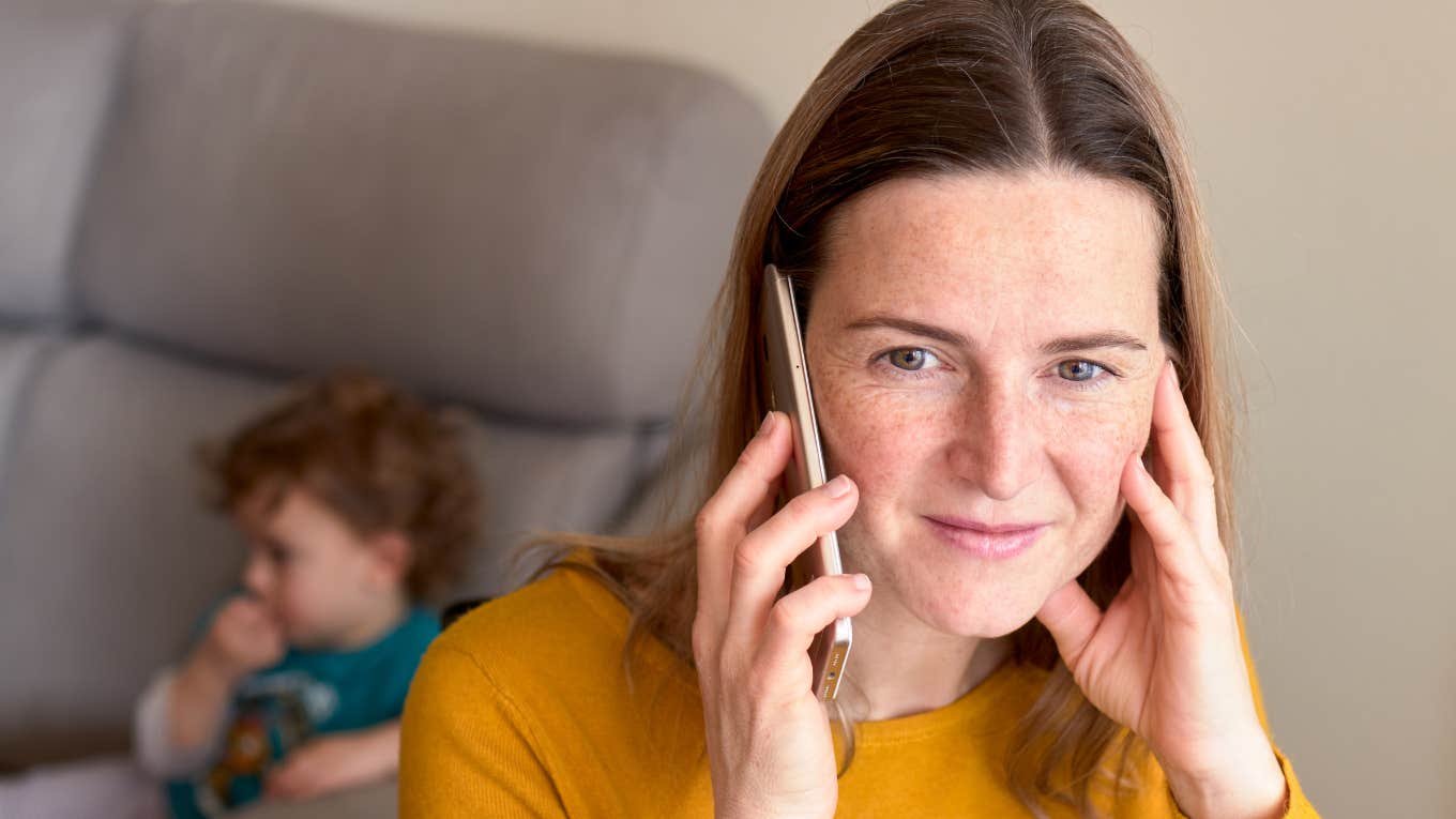 woman on the phone with young child in background