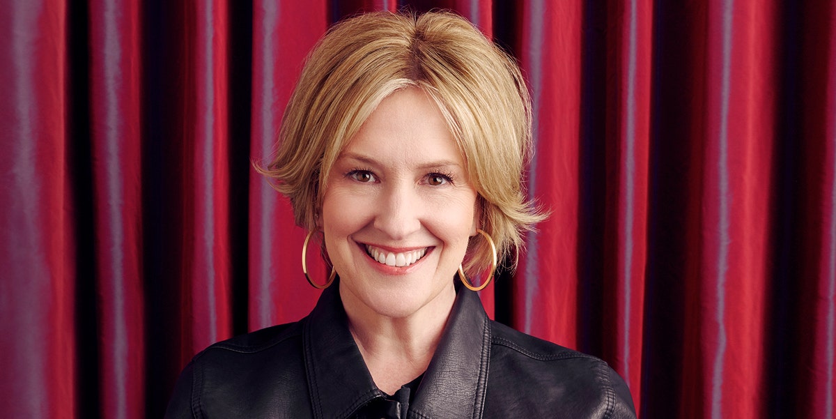 Headshot of Brené Brown looking sassy in front of a red backdrop