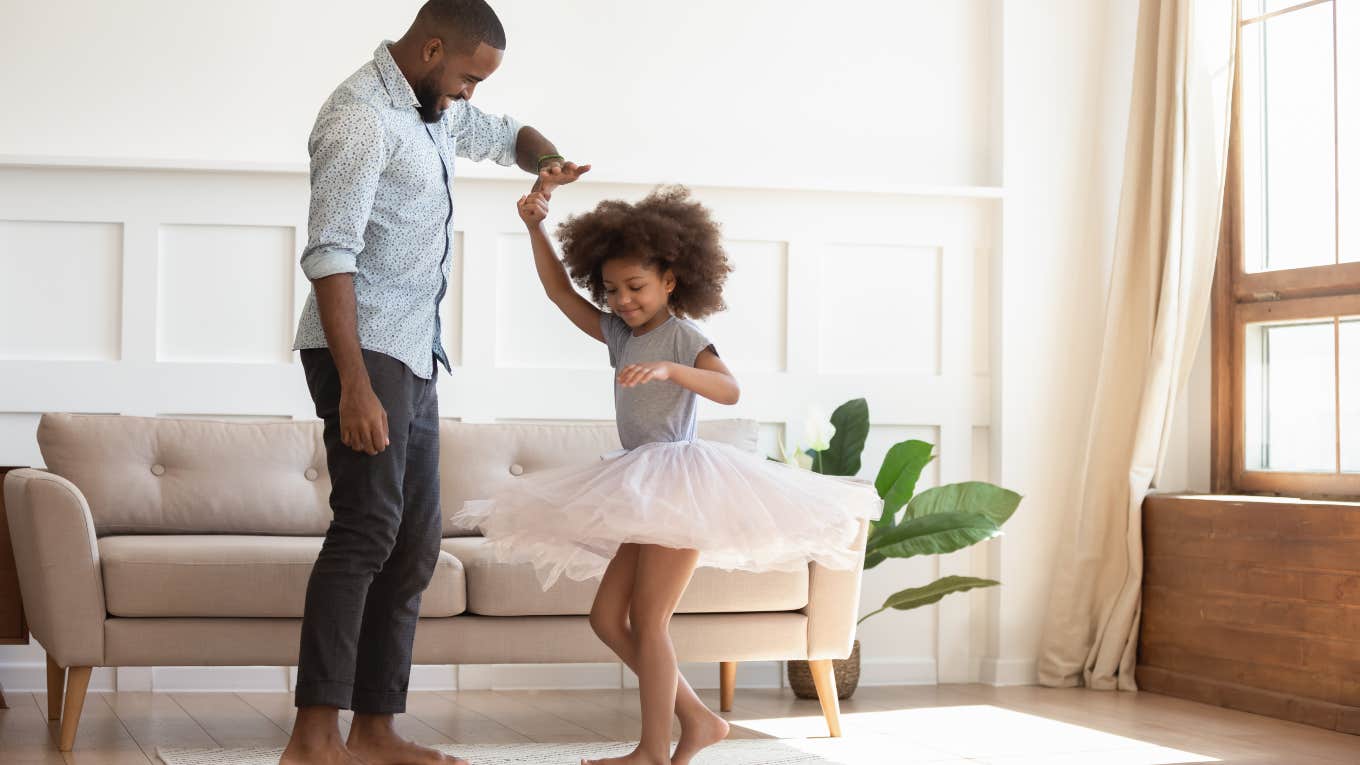 father and daughter dancing in living room