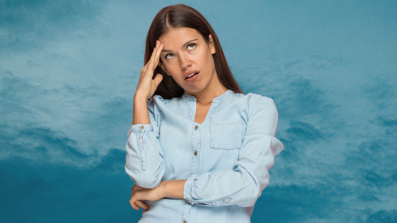 Woman looking frustrated in front of a blue background. 