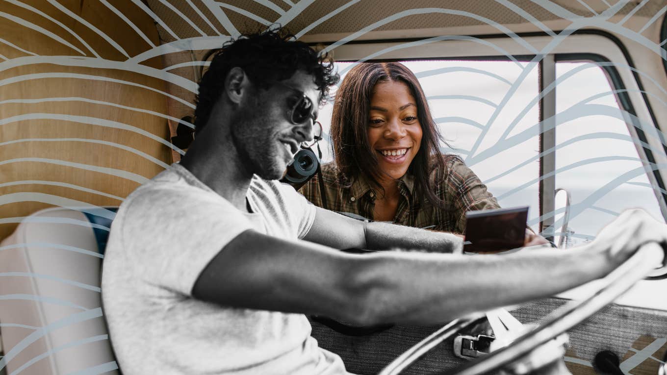 Man behind the wheel of a car, girl flirting showing him a photo