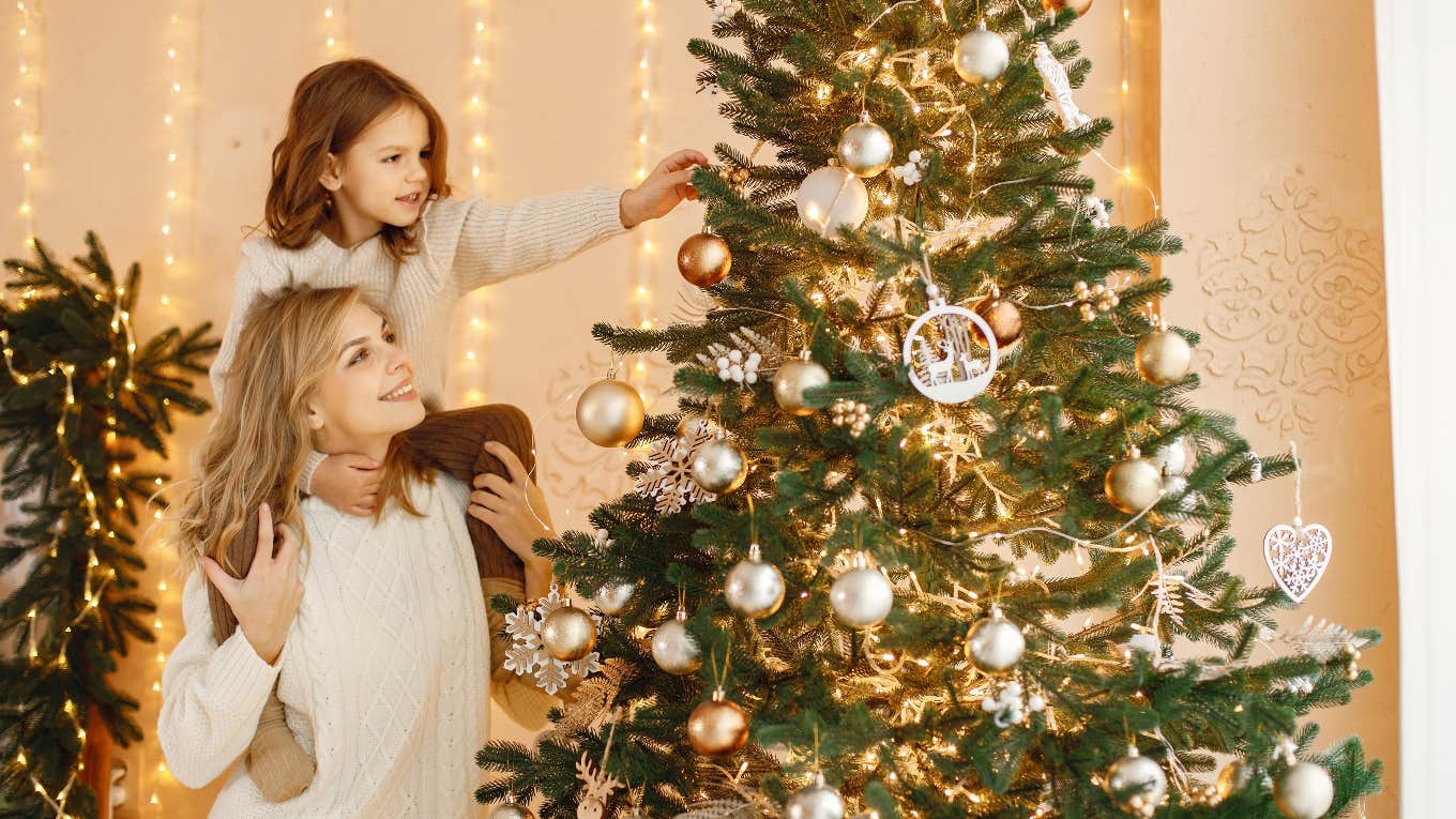 mom and daughter decorating christmas tree