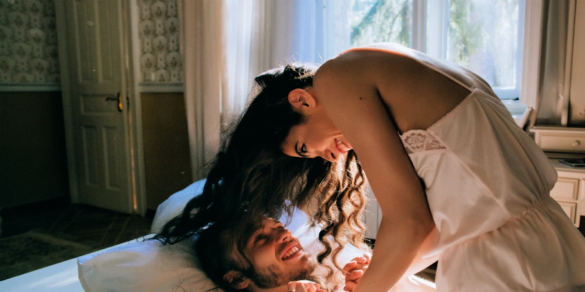 man and woman in bed laughing