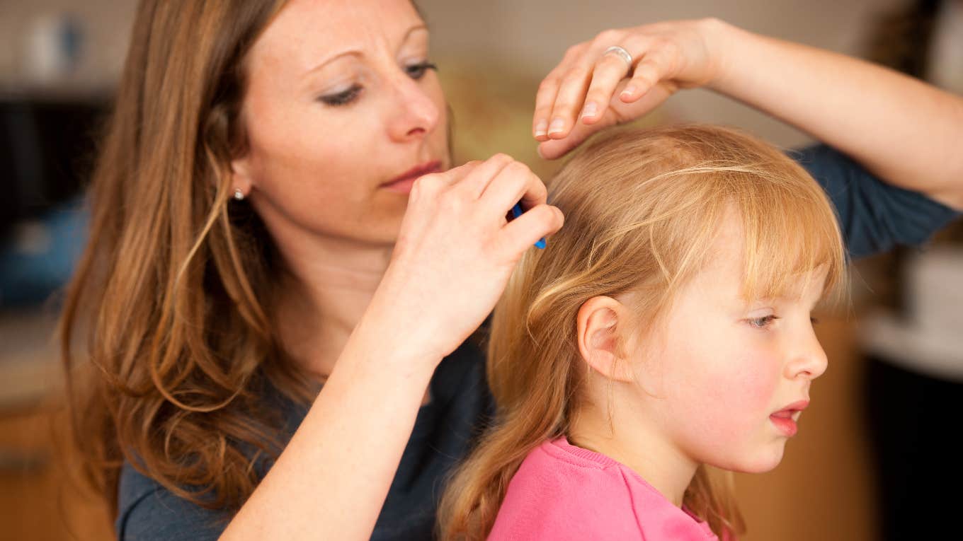 mother checking little girl's hair for lice