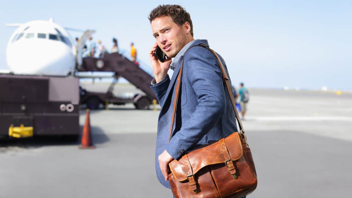 man, getting on plane, cellphone in hand