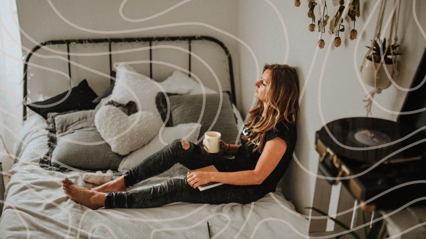 Woman sitting on bed drinking coffee 
