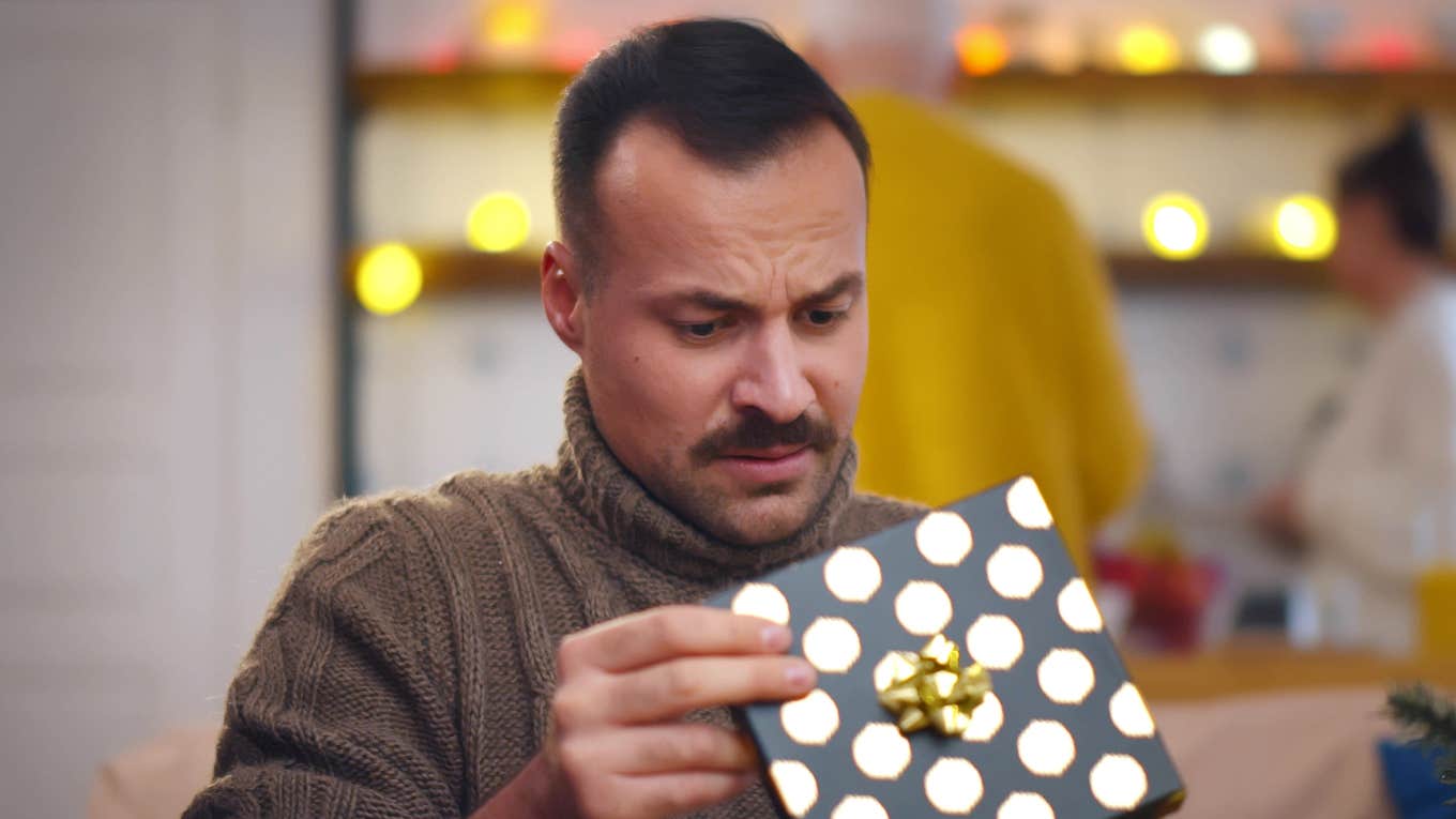 Man unhappy opening gift from wife