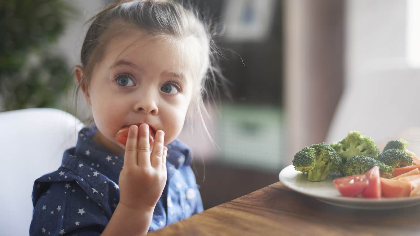 child eating vegetables at table