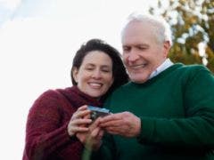 older happy married couple looking at photos