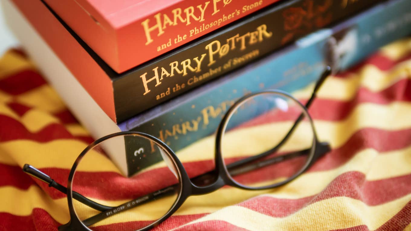 stack of Harry Potter books with a pair of round glasses