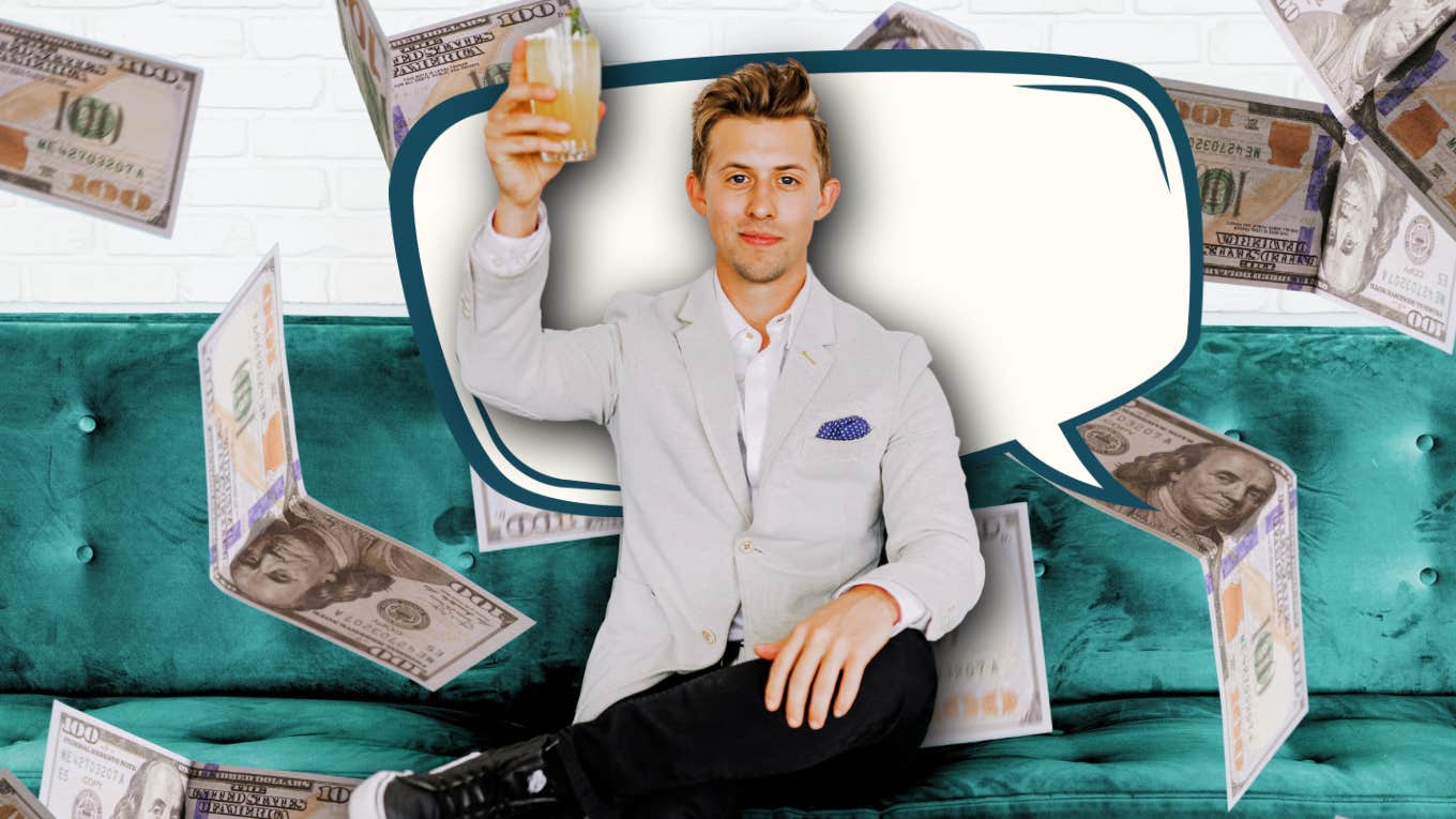 Wealthy man surrounded by money holding up a drink
