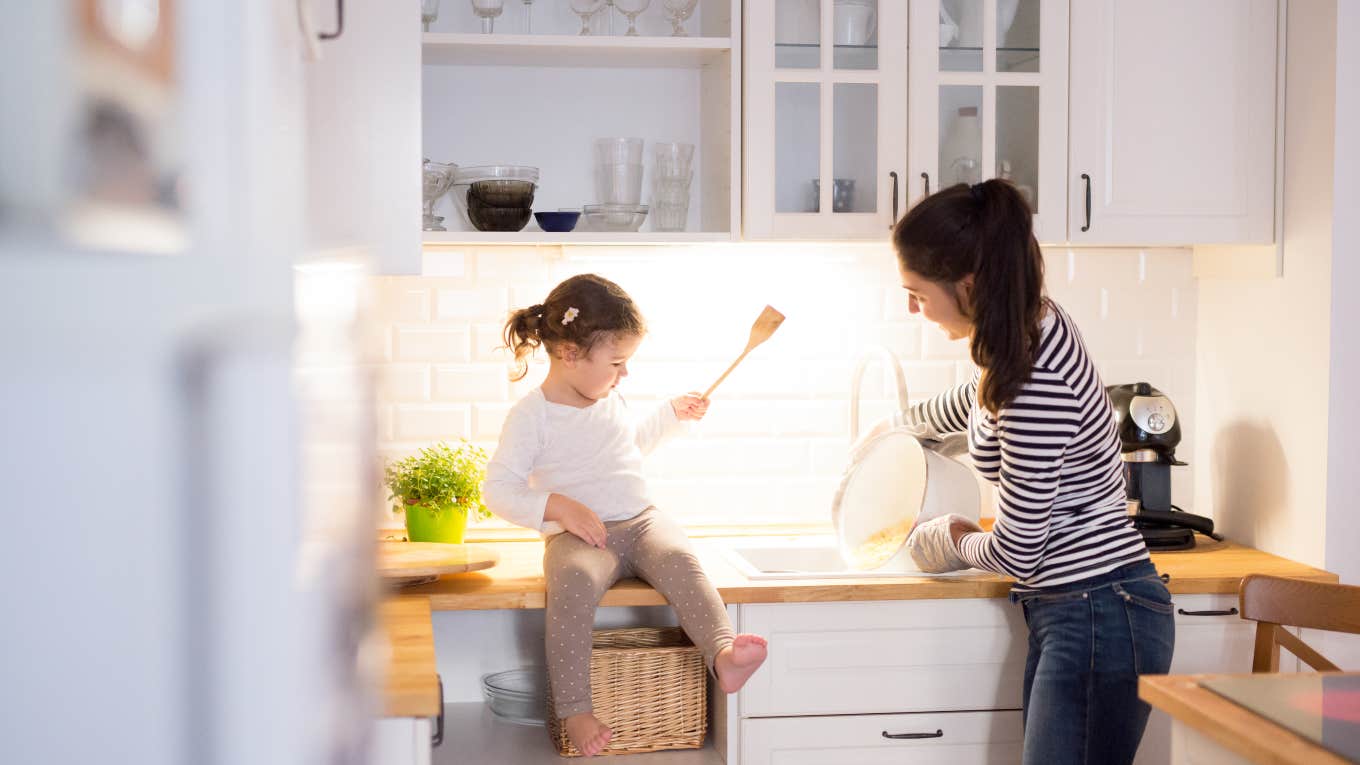 mom and toddler daughter cooking together in the kitchen