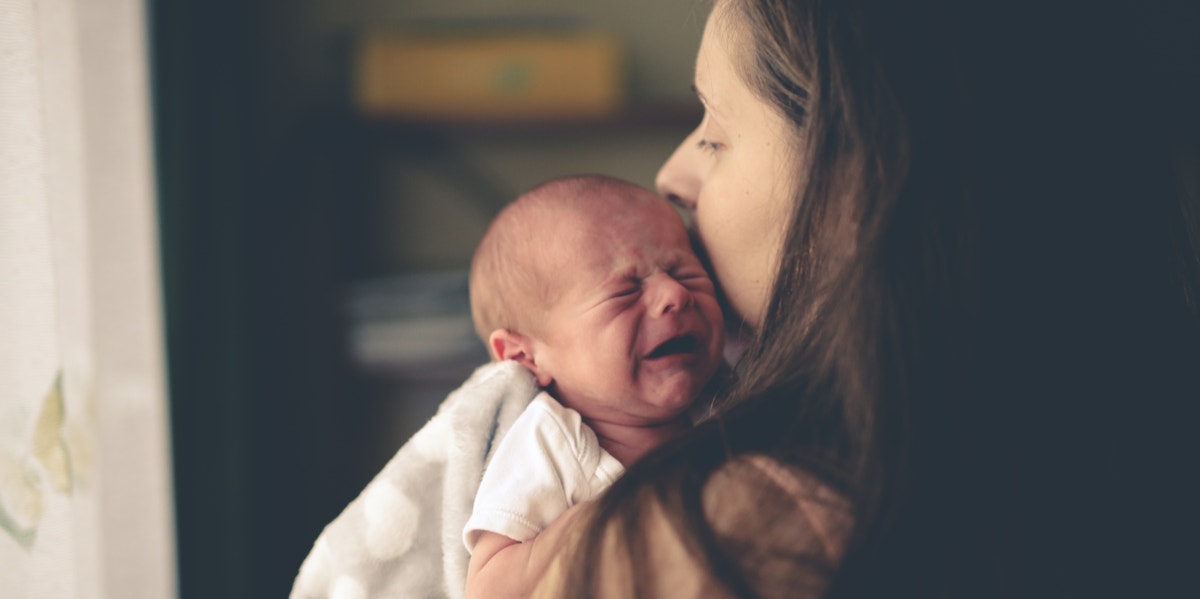 woman holding crying baby