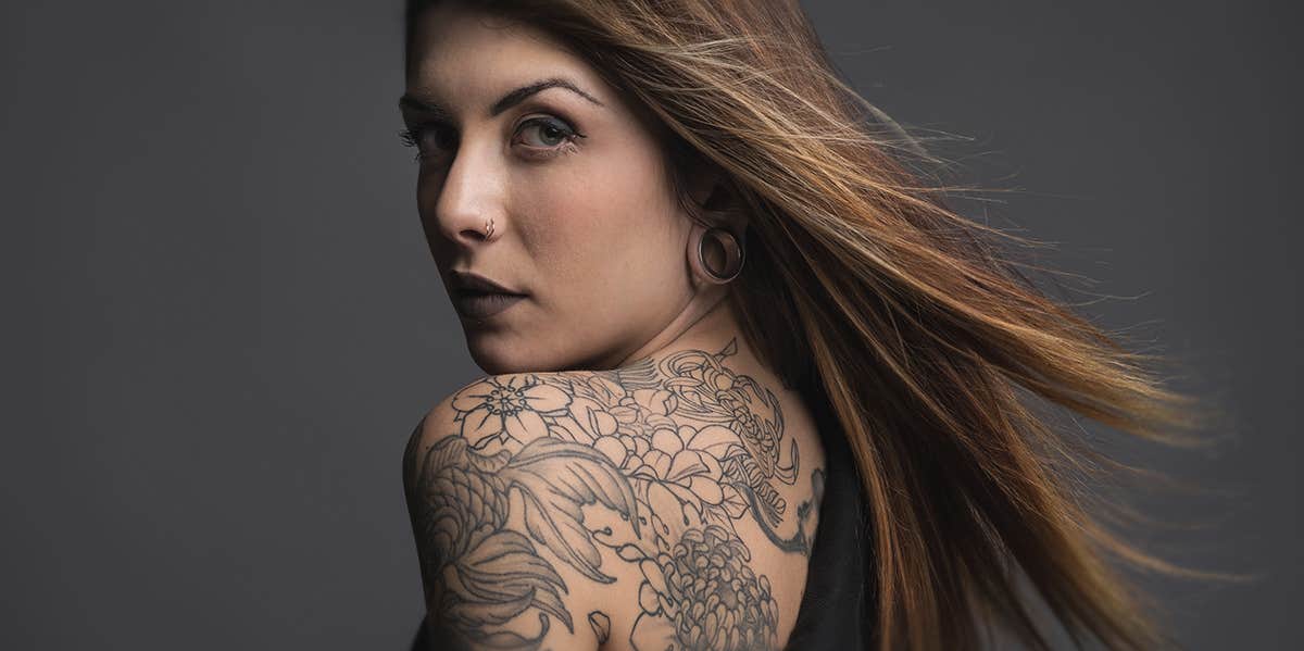 woman with tattoo on shoulder looking back