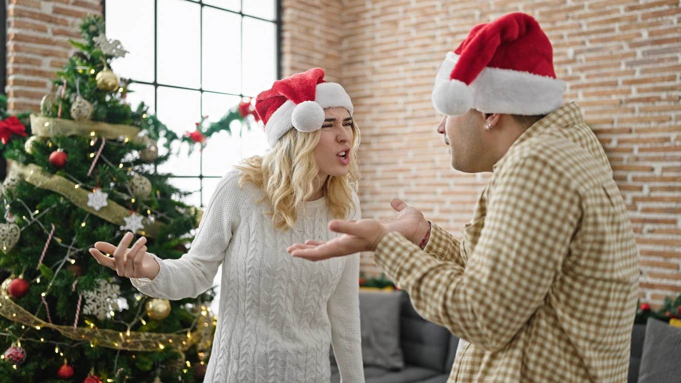man and woman fighting in front of Christmas tree