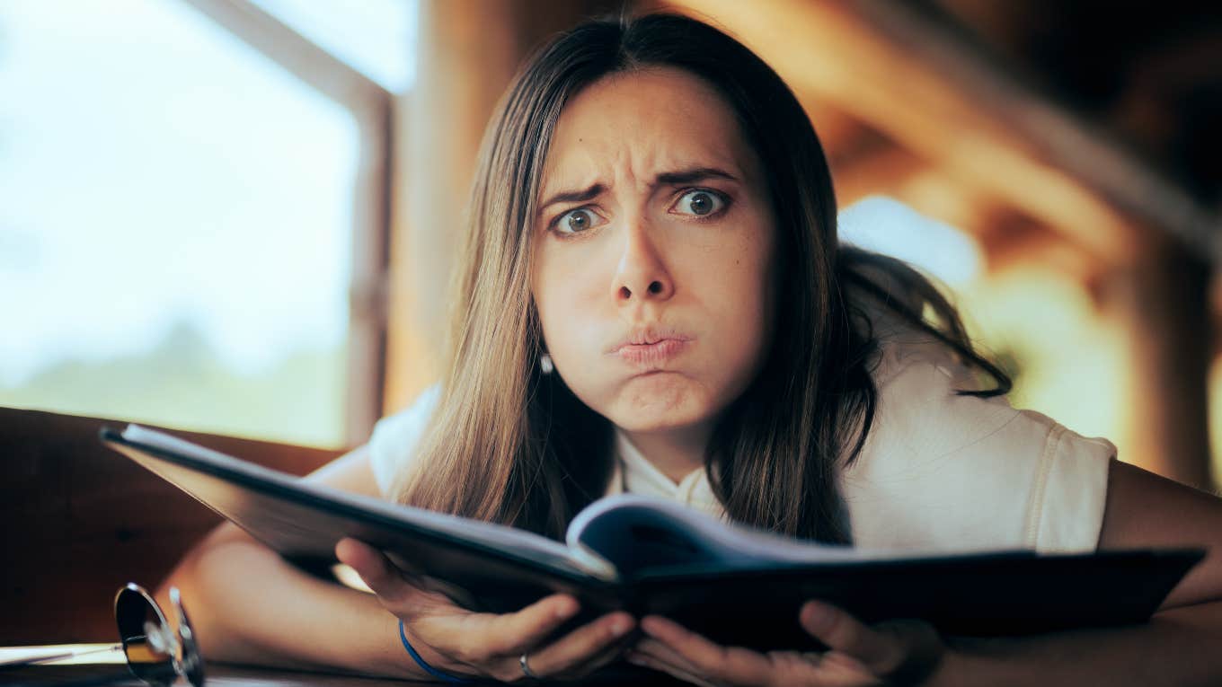 surprised, frustrated woman looking at menu
