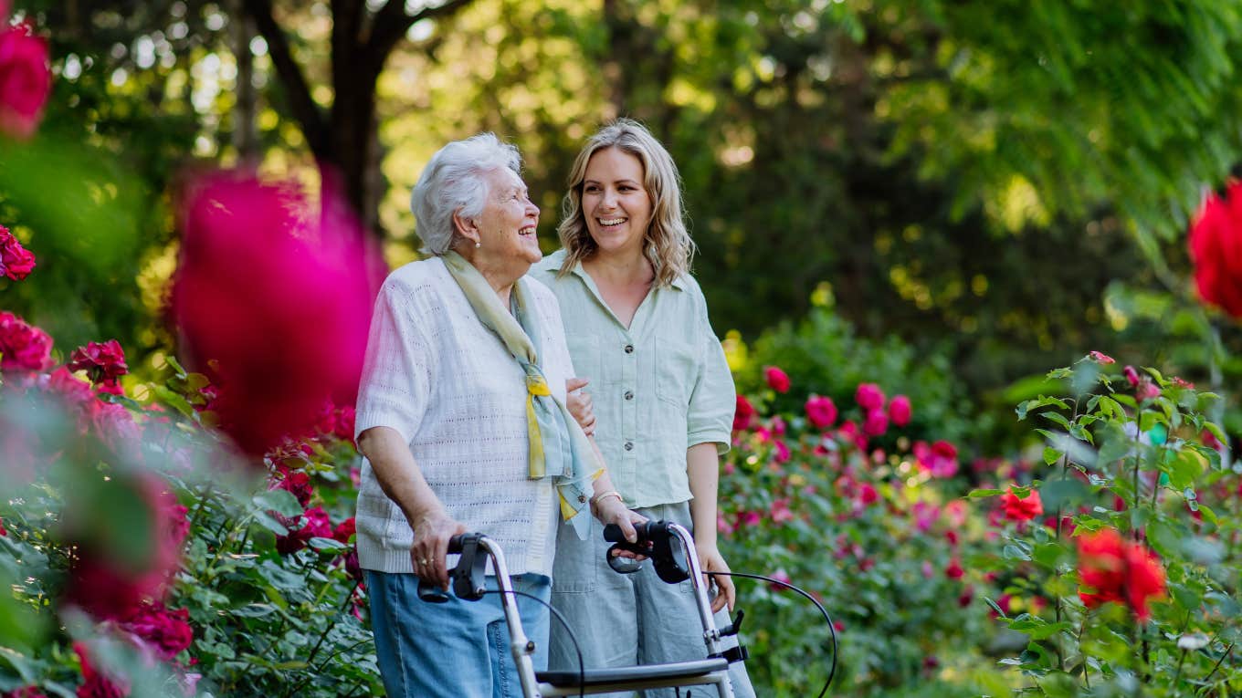 elderly woman and young woman walking around garden