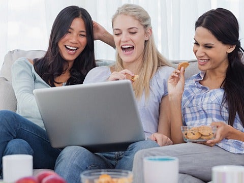 women laughing at laptop
