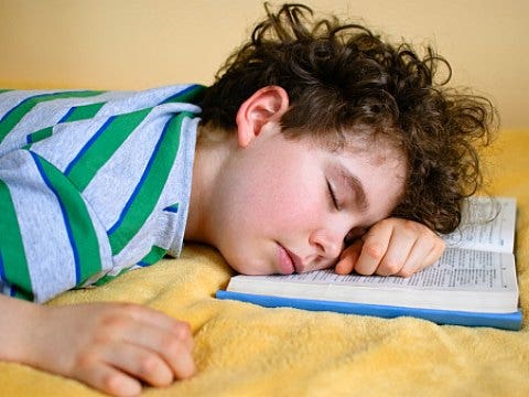 boy sleeping on book