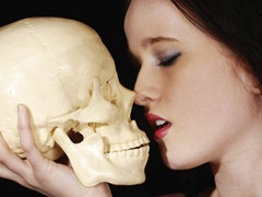 woman kissing skull