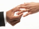 man putting wedding ring on woman