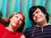 guy and girl listening to music on bed