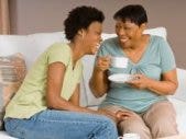 mother and daughter laughing on couch
