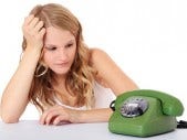 Don't hold your breath. young blonde woman waiting by the phone