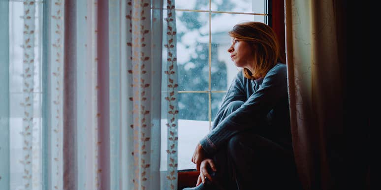 woman sulking by a window