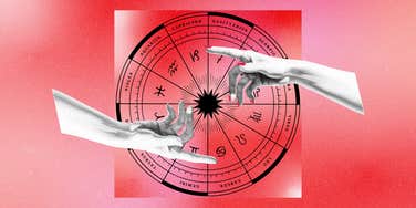 two hands reaching over zodiac wheel