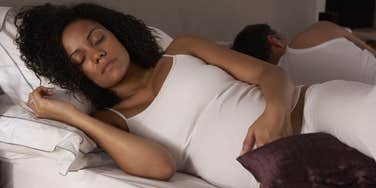 Pregnant Woman Trying to Sleep In Bed Next To Partner
