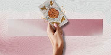 hand holding tarot card for horoscope may 19, 2024