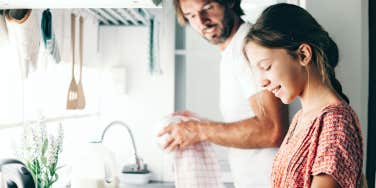 Father and young teen daughter in kitchen 