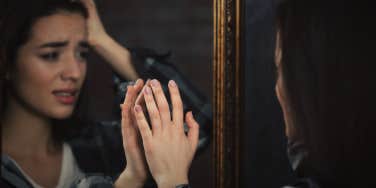 Woman looking at her self in the mirror 