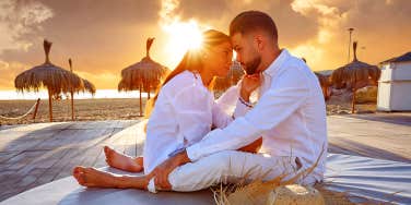 couple sitting in the sunset on honeymoon
