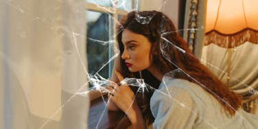 Woman looking out the window thinking she found love, to have it shattered