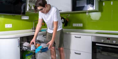 teen boy using dishwasher