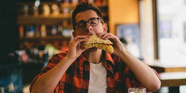 man eating sandwich at restaurant