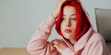 sad woman with red hair thinking